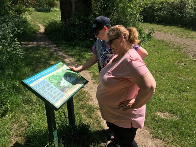 Shar and Sam read from an information board about the river Chess.